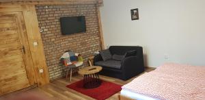 salon z krzesłem i telewizorem na murze z cegły w obiekcie Apartmán Krajčer w mieście Gierlachów