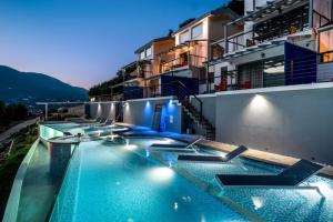 ein Pool an der Seite eines Gebäudes in der Nacht in der Unterkunft Sappho Boutique Suites in Vasiliki