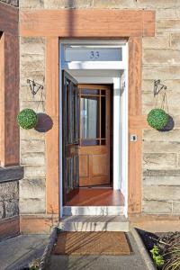 a front door of a house with two plants at Another Room in Edinburgh