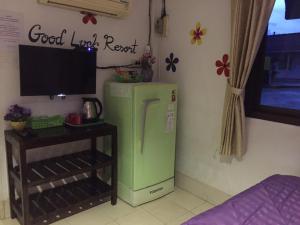 a green refrigerator in a room with a tv at goodluck resort@phayao in Phayao