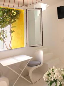 een wit kantoor met een wit bureau en een spiegel bij La maison jaune in Sète