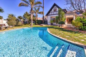 a swimming pool in front of a house at King George's Guest House in Port Elizabeth