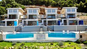 a large house with a swimming pool in front of it at Sappho Boutique Suites in Vasiliki