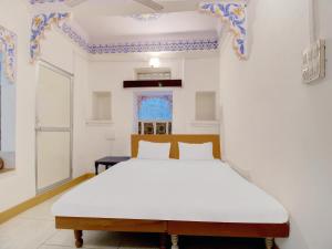 ein Schlafzimmer mit einem weißen Bett in einem Zimmer in der Unterkunft Island Tower Guest house in Udaipur