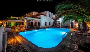 a large swimming pool in front of a house at night at Annita's Village Hotel in Agia Anna Naxos