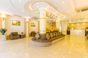 Minh Tam Hotel and Spa في مدينة هوشي منه: لوبي فندق فيه عامود كبير وزهور