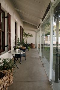 an empty porch with tables and chairs and plants at Heritage House in Stellenbosch