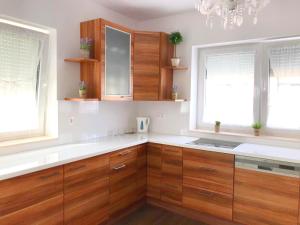a kitchen with wooden cabinets and two windows at Villa Residence in Sînmartin +48 photos