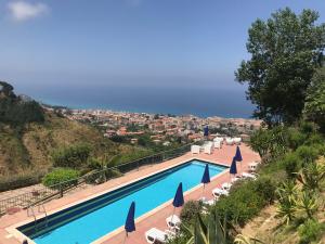 a swimming pool with chairs and umbrellas and a city at Villa Del Conte in Drapia +66 photos