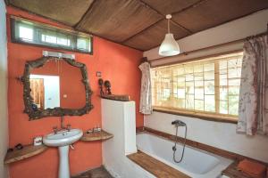 a bathroom with a sink and a tub and a mirror at Hillside Retreat – Africa Amini Life in Usa River +68 photos