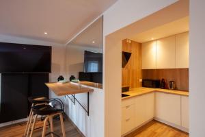 a kitchen with white cabinets and a black refrigerator at Apartament Rynek N°21 in Gliwice
