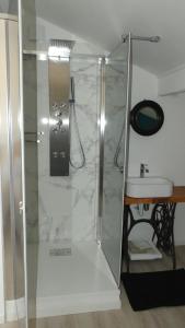 a shower with a glass door next to a sink at Bleuvelours in Andernos-les-Bains