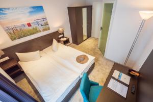 1 dormitorio con 1 cama blanca y 1 silla azul en Hotel Villa Belvedere en Binz