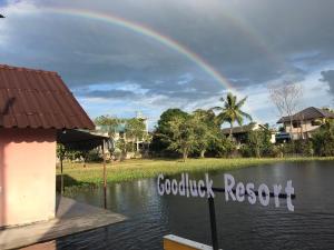 un arcobaleno sopra un corpo d'acqua con una casa di goodluck resort@phayao a Phayao