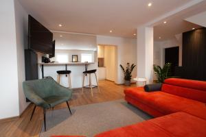 a living room with a red couch and a television at Apartament Rynek N°21 in Gliwice
