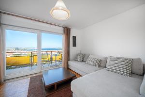 a living room with a couch and a large window at Apartmani Patača in Vodice