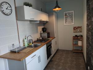 a kitchen with a sink and a clock on the wall at OperaApart in Warsaw