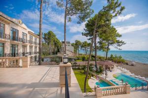 an exterior view of a resort with a swimming pool and the ocean at Black Sea Riviera Hotel in Shekhvetili