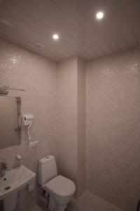 a bathroom with a toilet and a sink at Black Sea Riviera Hotel in Shekvetili