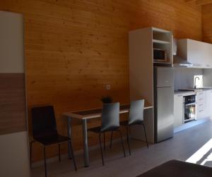 a kitchen with a table and chairs and a refrigerator at Recinto As Casiñas in Cangas de Morrazo