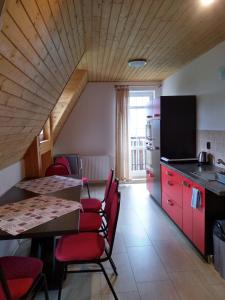 a kitchen with red cabinets and a table and chairs at Penzión Chata Valaška in Vysoke Tatry - Dolny Smokovec