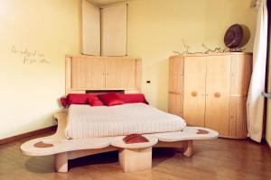 a bedroom with a wooden bed with red pillows at eco Hotel Milano & BioRiso Restaurant in Milan