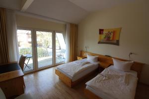 a hotel room with two beds and a balcony at Franziskaner am Markt in Löningen