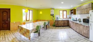 eine Küche mit einem großen Holztisch und gelben Wänden in der Unterkunft Guest House Mart Villa in Martvili