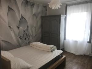 - une chambre avec un lit et un mur dans l'établissement Cottage familial, à Ozeville