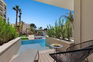 un patio con mesa, sillas y piscina en Hotel Paradiso Garden, en Playa de Palma