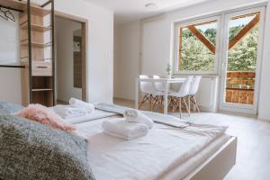 - une chambre avec un lit, une table et des chaises dans l'établissement Apartmaji Triglav, à Bohinj