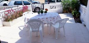 una mesa y sillas blancas con una mesa y flores en Gregal Vidaber Adosado, en Oropesa del Mar