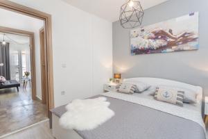 um quarto com uma grande cama branca com um quadro na parede em Apartment Marina Pavić 02 em Hvar