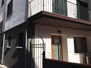 - un bâtiment avec un portail et un balcon dans l'établissement CAV Mameli, à Dorgali