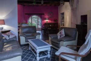 uma sala de estar com paredes roxas e mobiliário de couro em la Fadette em Saint-Lizier