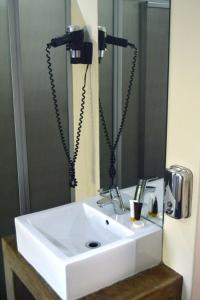 a bathroom sink with a hair dryer and a mirror at Essenwood Park Hotel in Durban