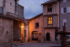 un vieux bâtiment avec une statue au milieu d'une rue dans l'établissement la Fadette, à Saint-Lizier