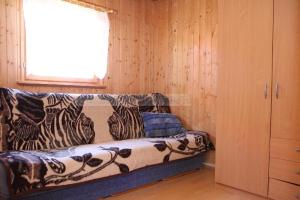 a couch sitting in a room with a window at Domki u Karasia in Rusinowo