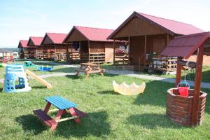 a playground with wooden play equipment in the grass at Domki u Karasia in Rusinowo