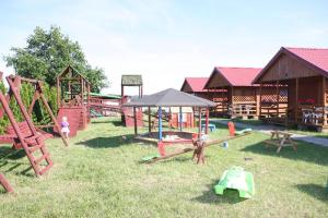 a playground with a bunch of play equipment in the grass at Domki u Karasia in Rusinowo