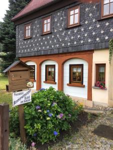 a house with a sign in front of it at Ferienwohnung Schulze Jonsdorf in Kurort Jonsdorf
