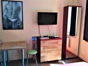 a room with a dresser with a tv and a chair at Akt Studio Apartment City Centre in Krakow