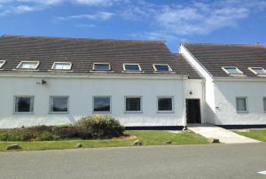 a white house with a roof at Valley Lodge in Trearddur