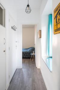 einen Flur mit weißen Wänden und Holzböden sowie ein Schlafzimmer in der Unterkunft Appartement Cosy 4P - L'Ar Zenith in Saint-Malo