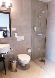 uma casa de banho com um chuveiro, um WC e um lavatório. em Banken Hotel em Haugesund