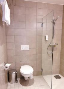 uma casa de banho com um WC e uma cabina de duche em vidro. em Banken Hotel em Haugesund