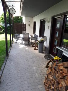 a patio with a table and chairs and a clock at Ferienwohnung am Sorpesee in Allendorf