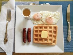 a plate with eggs and waffles and a cup of coffee at Belfort House B&B in Valencia