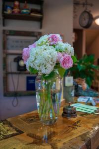 a vase filled with pink and white flowers on a table at Guest House Blizhnie Dubki in Saint Petersburg