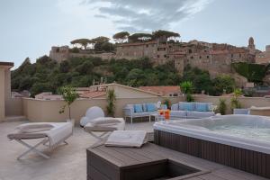 a balcony with a hot tub and a view of a city at Roma Hotel in Castiglione della Pescaia